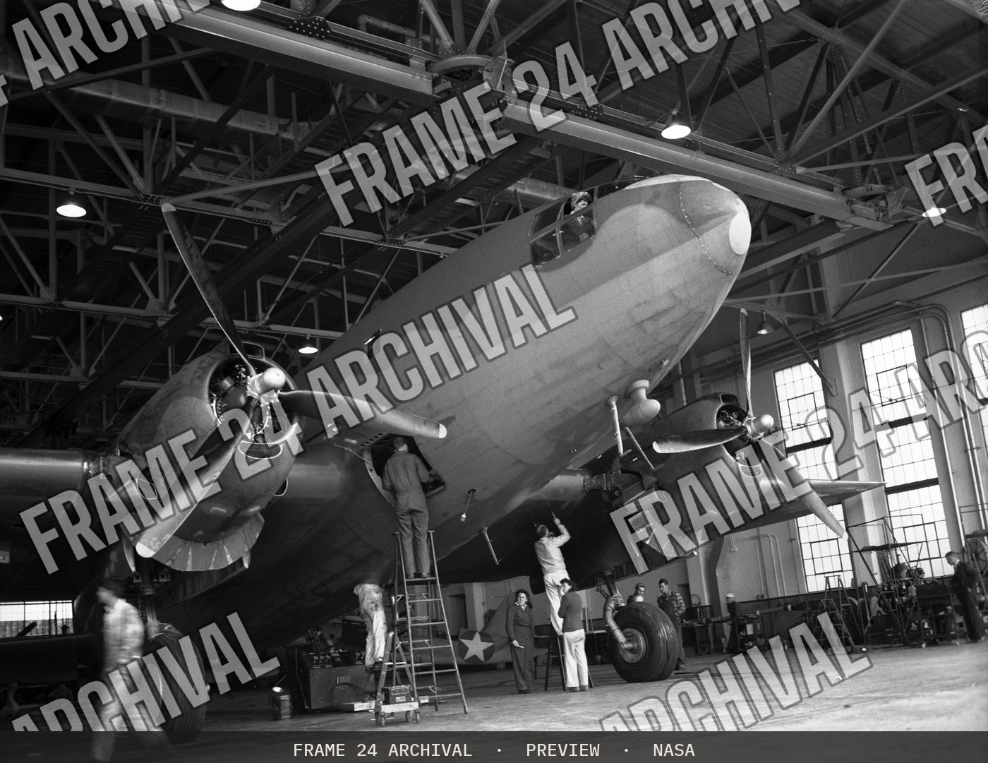Ames mechanics working on C-46 airplane in front of hangar (1943), restored vintage black and white photograph