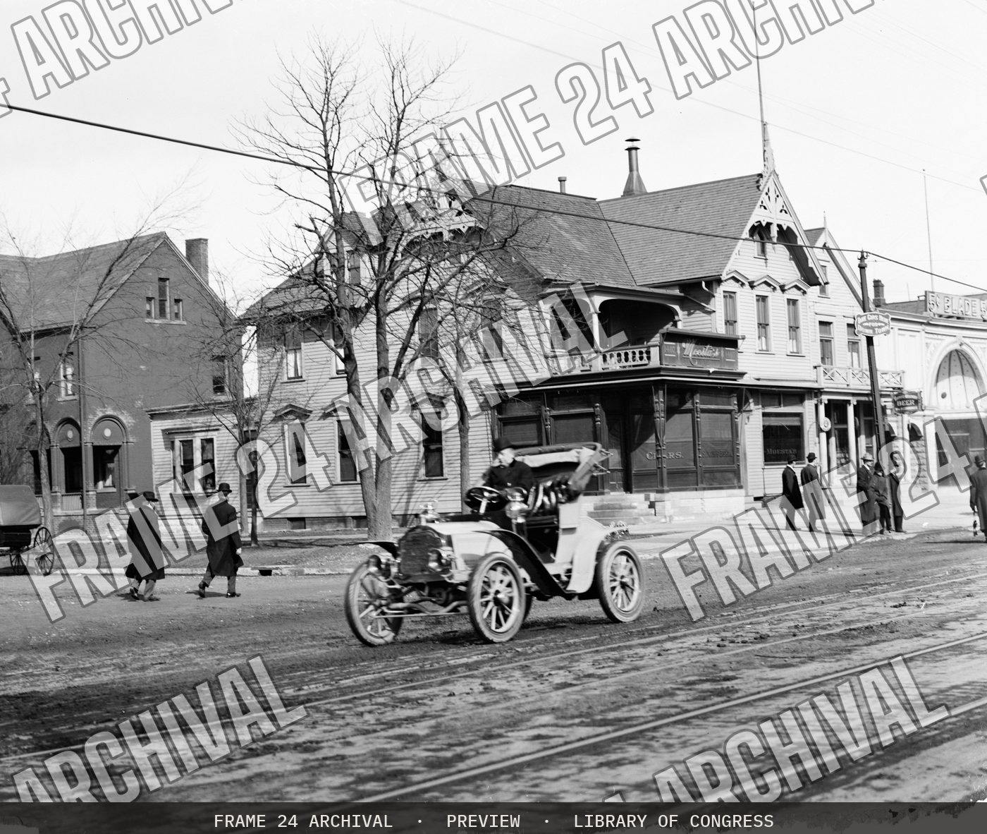 Automobile on town street (1900), restored vintage black and white photograph