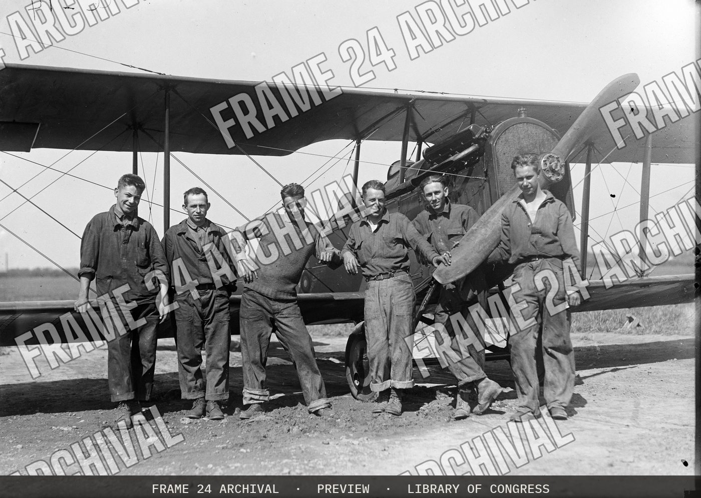Group at airplane (1915), restored vintage black and white photograph